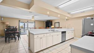 a large kitchen with a sink and a table at Sixty-Five & Salty Bay View 65 in Orange Beach