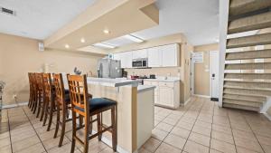 a kitchen with a counter and chairs in a room at Sixty-Five & Salty Bay View 65 in Orange Beach
