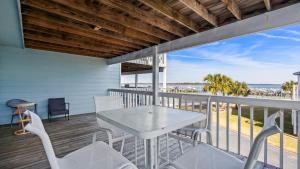 a balcony with a table and chairs and a view of the ocean at Sixty-Five & Salty Bay View 65 in Orange Beach
