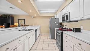 a kitchen with white cabinets and a stainless steel refrigerator at Sixty-Five & Salty Bay View 65 in Orange Beach