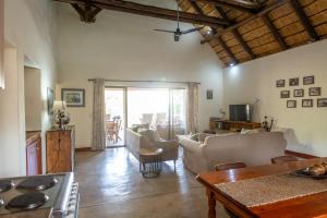 a living room with a couch and a table at Rukiya Safari Camp in Hoedspruit