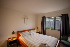 a bedroom with a bed and a window at Great for Couples - Families - Groups in Mangawhai