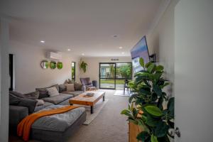 a living room with a couch and a table at Great for Couples - Families - Groups in Mangawhai