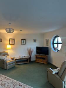 a living room with a couch and a television at Seaside Penthouse 2 in Largs
