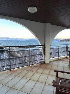 a view of the ocean from a balcony with a bench at Seaside Penthouse 2 in Largs