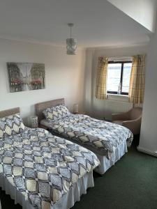 a bedroom with two beds and a couch at Seaside Penthouse 2 in Largs