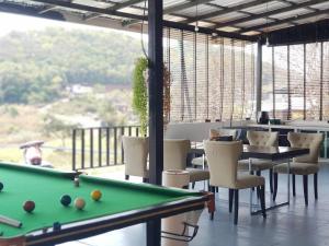 a room with a pool table and chairs and a window at Pool&chill kohlarn in Ko Larn