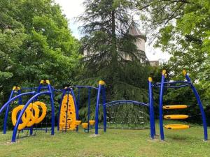 a playground with yellow and blue equipment in a park at Chalet accessible - 4 pers - Terrasse - API-1-52-1278 in Challes-les-Eaux
