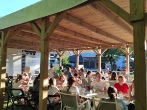 a group of people sitting at tables in an outdoor restaurant at Chalet accessible - 4 pers - Terrasse - API-1-52-1278 in Challes-les-Eaux