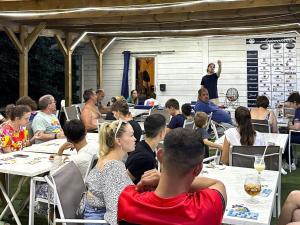 a group of people sitting at tables listening to a speaker at Chalet 2 Pers avec Terrasse à Challes-les-Eaux - API-1-52-1283 in Challes-les-Eaux +18 photos