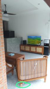 a living room with two tables and a television at Villa Casa Delta Canggu in Canggu