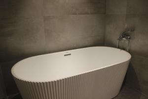 a white bath tub in a bathroom with a wall at Hotel Crown Plaza in Kathmandu +24 photos