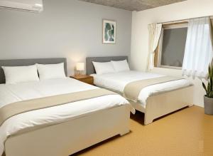a bedroom with two beds and a window at Sunshine in Tokyo