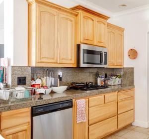 a kitchen with wooden cabinets and a stainless steel dishwasher at The Ark in Redding