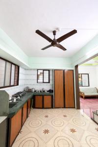 a large kitchen with a ceiling fan at Peaceful Family Bungalow Near Mahalakshmi Temple in Kolhapur
