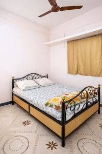 a bedroom with a bed and a ceiling fan at Peaceful Family Bungalow Near Mahalakshmi Temple in Kolhapur