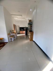 a large white room with a kitchen and a table at Ulya Kecil in Diyeng
