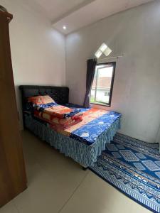 a small bed in a room with a window at Ulya Kecil in Diyeng