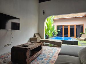 a living room with a couch and a table at Villa Lamorna in Krui +4 photos
