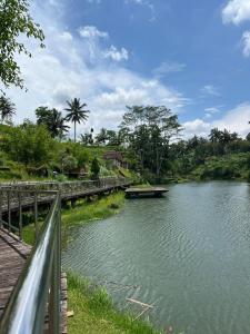 a river with a bridge next to a fence at Live lombok homestay in Batukliang