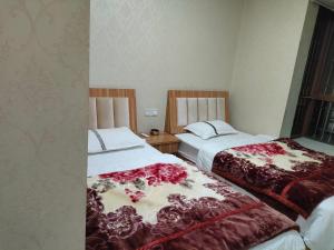 two beds sitting next to each other in a room at 春栖客栈 in Chuanxingpu