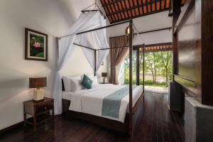 a bedroom with a canopy bed and a window at Aravinda Resort Ninh Binh in Ninh Binh +35 photos