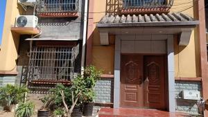 a building with a brown door and some plants at 春栖客栈 in Chuanxingpu