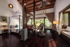 a bedroom with a bed and a desk and a chair at Aravinda Resort Ninh Binh in Ninh Binh