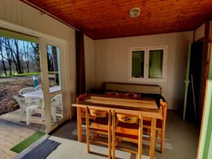 a screened in porch with a table and chairs at Chalet 8 Pers - Terrasse - Equipement bébé - API-1-52-1519 in Beaudreix