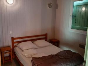 a small bedroom with a bed and a window at Chalet 8 Pers - Terrasse - Equipement bébé - API-1-52-1519 in Beaudreix