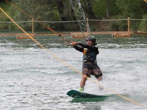 a man holding onto a rope while water skiing at Chalet 8 Pers - Terrasse - Equipement bébé - API-1-52-1519 in Beaudreix