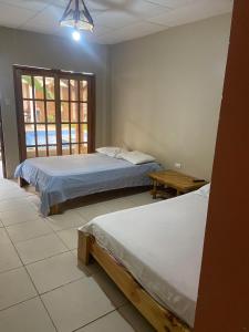 a bedroom with two beds and a window at Villa en Salango con piscina in Salango