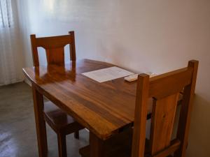 a wooden table with two chairs and a paper on it at HilNer's Beach Resort in Alegria