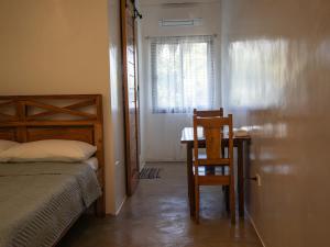 a bedroom with a bed and a table and a chair at HilNer's Beach Resort in Alegria +3 photos