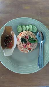 a plate with a sandwich and pickles on a table at Sunshine's Hill in Ko Lanta