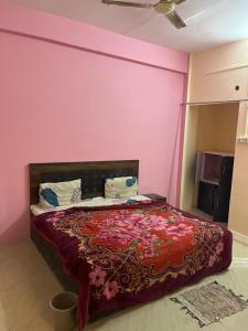 a bedroom with a bed with a pink wall at Hotel flamingo inn in Rewa