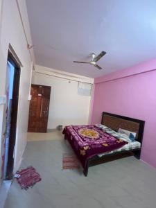 a bedroom with a bed and a pink wall at Hotel flamingo inn in Rewa
