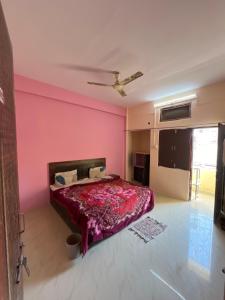 a bedroom with a bed with a pink wall at Hotel flamingo inn in Rewa