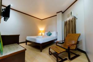 a room with a bed and a chair and a television at Madonna Hometel and Suites in Panabo +118 photos