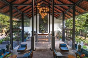 a restaurant with blue chairs and a chandelier at Aravinda Resort Ninh Binh in Ninh Binh