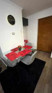 a dining room table with a red tablecloth and a clock at Condo luminity exclusivo 2D-2B incluye piscina parking y wifi gratis check in y seguridad 24 hrs in Los Ángeles