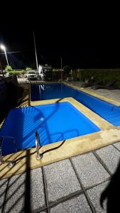 a blue swimming pool at night at Condo luminity exclusivo 2D-2B incluye piscina parking y wifi gratis check in y seguridad 24 hrs in Los Ángeles