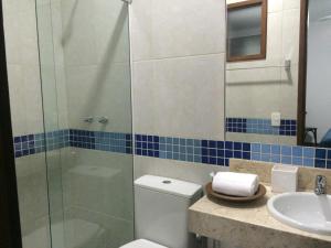 a bathroom with a shower and a toilet and a sink at Pousada Manjericão in Guaramiranga +41 photos