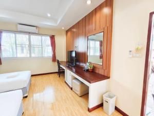 a bathroom with a desk with a tv and a mirror at โรงแรมสบายโฮเทล โคราช in Nakhon Ratchasima