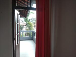 an open door to a balcony with a red curtain at Negombo New Villa in Negombo