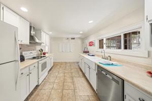 a large kitchen with white cabinets and appliances at Twin Fawns - EV #3417 in Estes Park