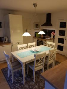 cocina con mesa blanca y sillas en Haus Adele, en Laboe