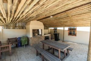 a living room with a wooden ceiling and benches at Deer Cottage in Kirkwood
