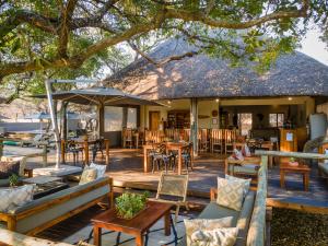 a deck with tables and chairs and a restaurant at Rukiya Safari Camp in Hoedspruit