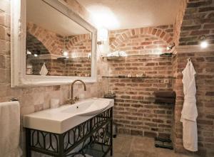 a bathroom with a sink and a brick wall at Hotel Azimut in Sveti Stefan